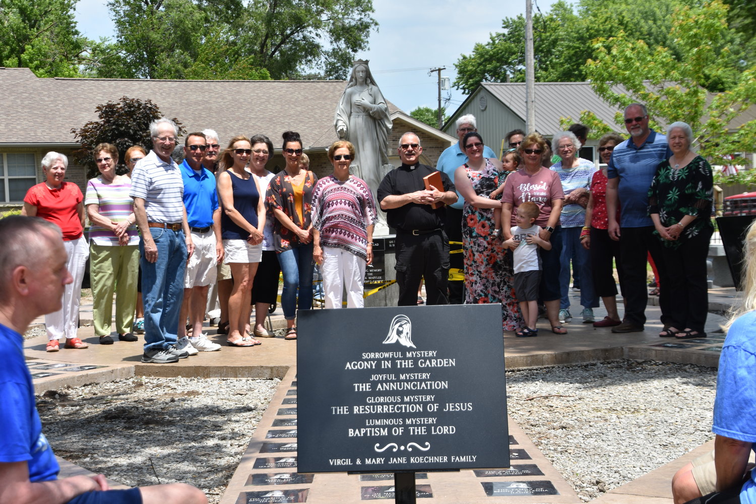 Parishioners and friends of Father Anthony Rinaldo gather in the Rosary Garden outside St. Andrew Church shortly before the landscaping was completed this summer.